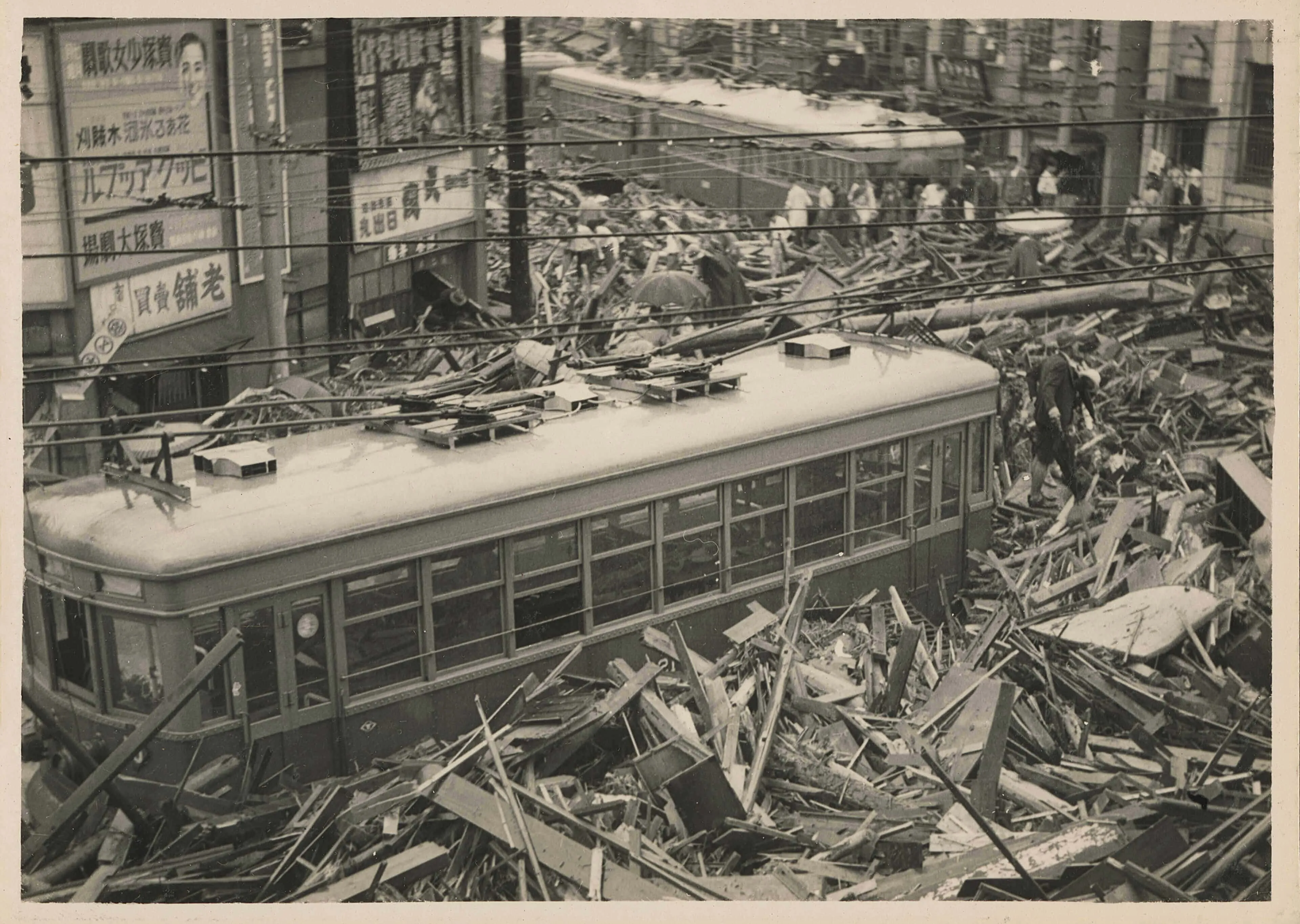 1938年に起きた阪神大水害で、神戸三越前で流れてきた板や土砂で埋まって路面電車が立ち往生している写真。