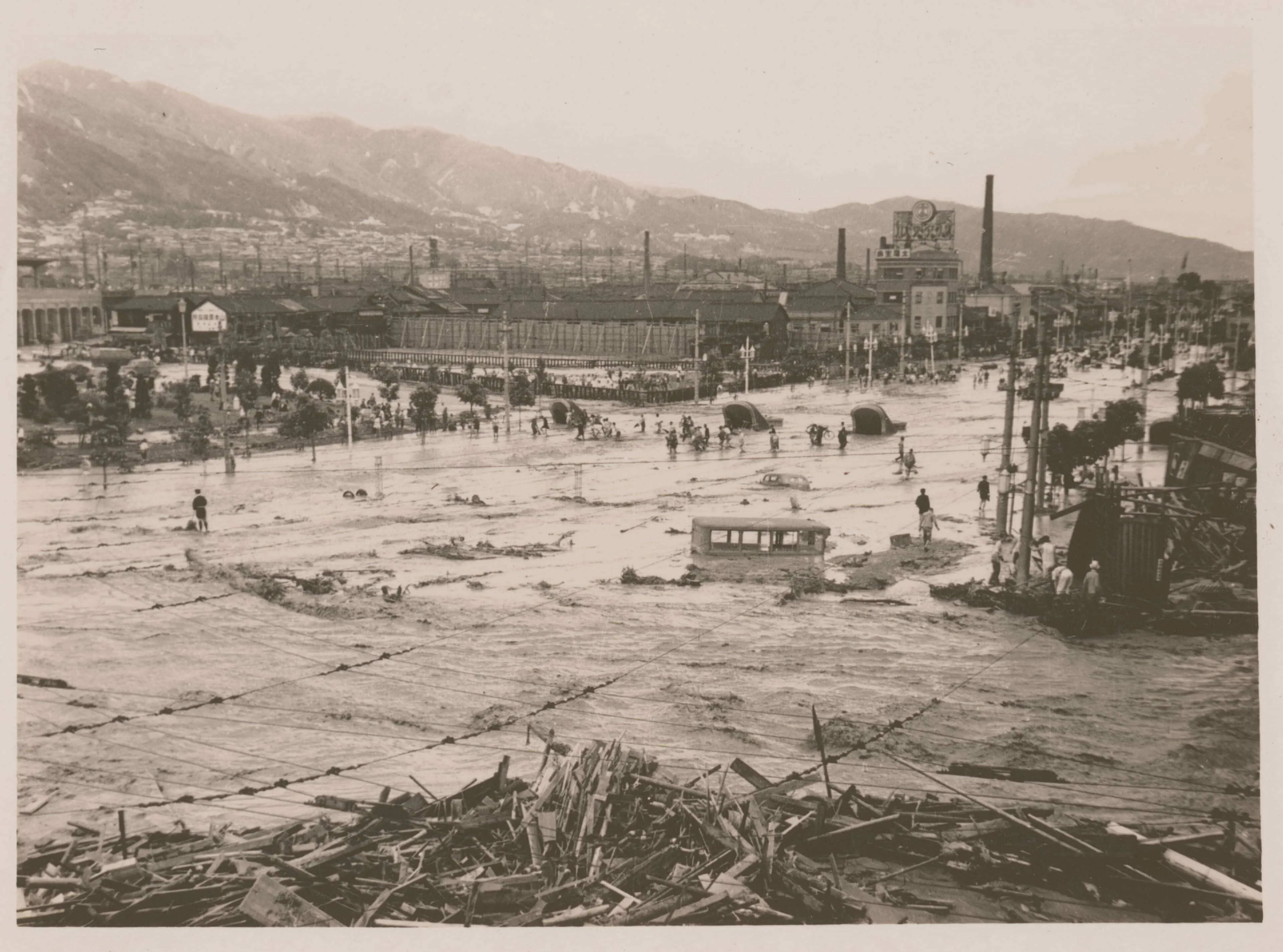 1938年に起きた阪神大水害で、三ノ宮駅前でバスや自動車が泥の中に埋まっている写真